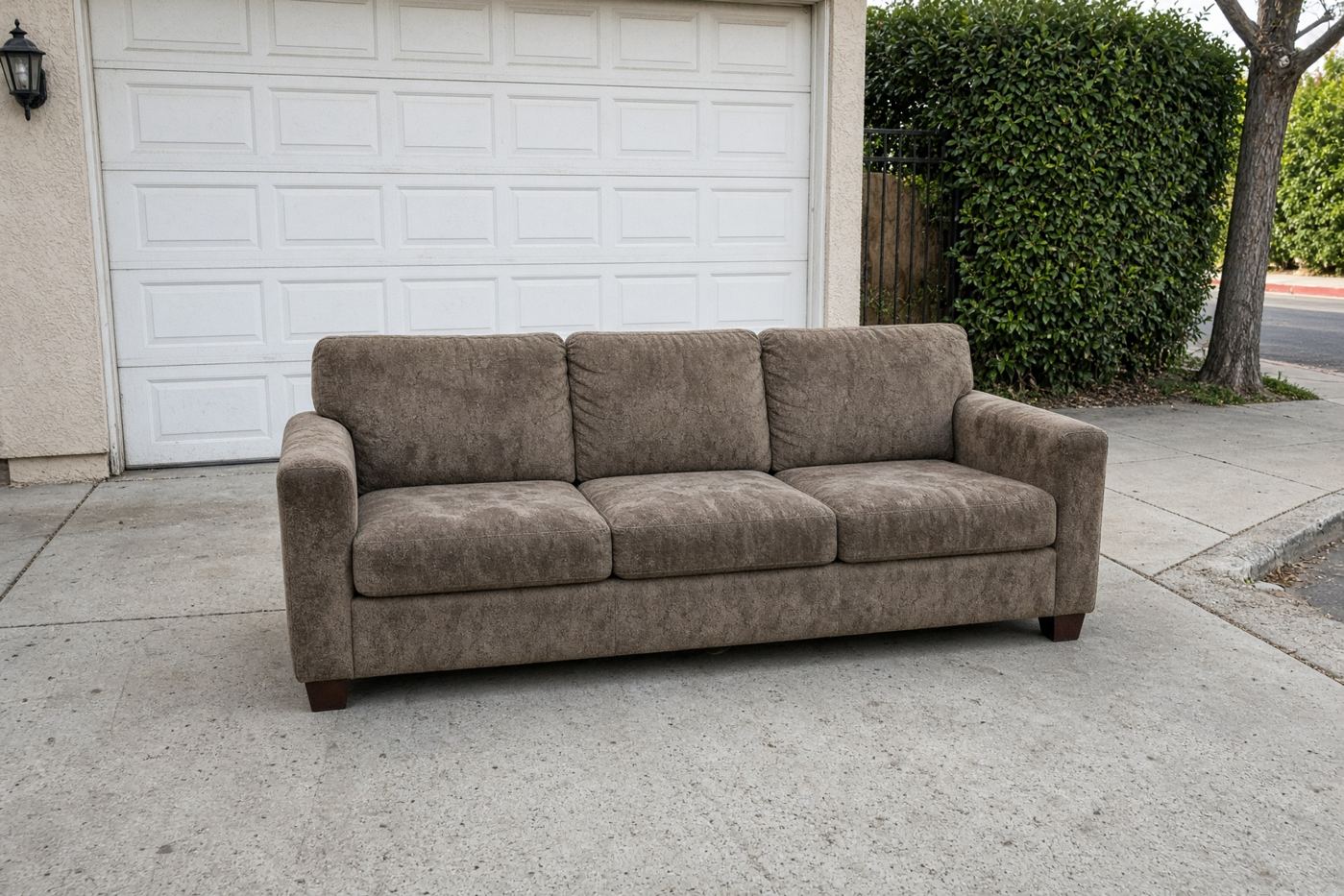 Three-seat sofa on a San Diego driveway ready for couch removal