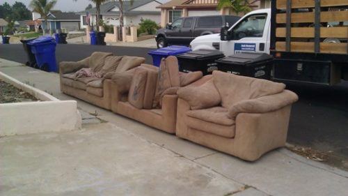 Three-piece brown sectional at the curb with Fred's dump truck for sectional removal