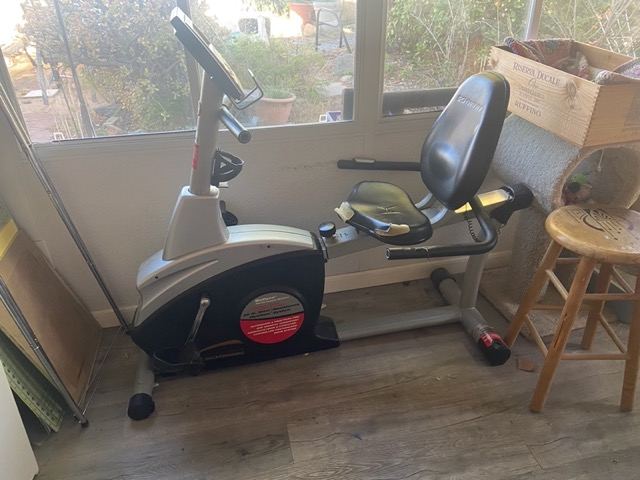 Stationary recumbent bike indoors staged for pickup