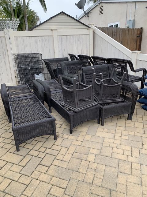 Wicker patio furniture set stacked on pavers for junk removal