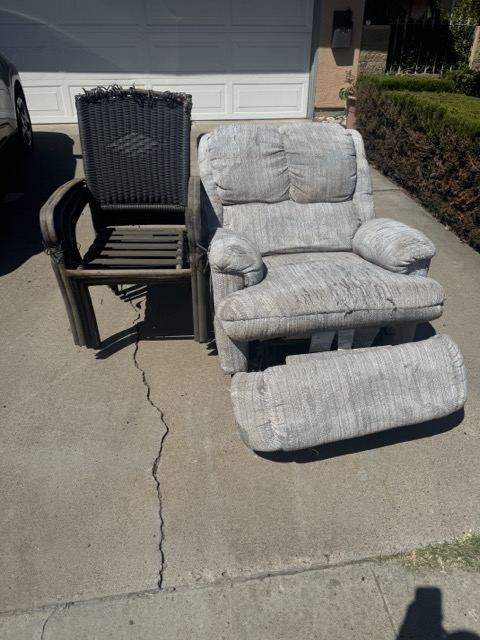 Recliner and patio chair on a driveway for furniture disposal