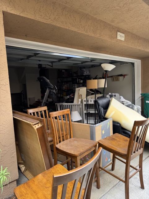 Garage doorway stacked with chairs and old furniture for pickup