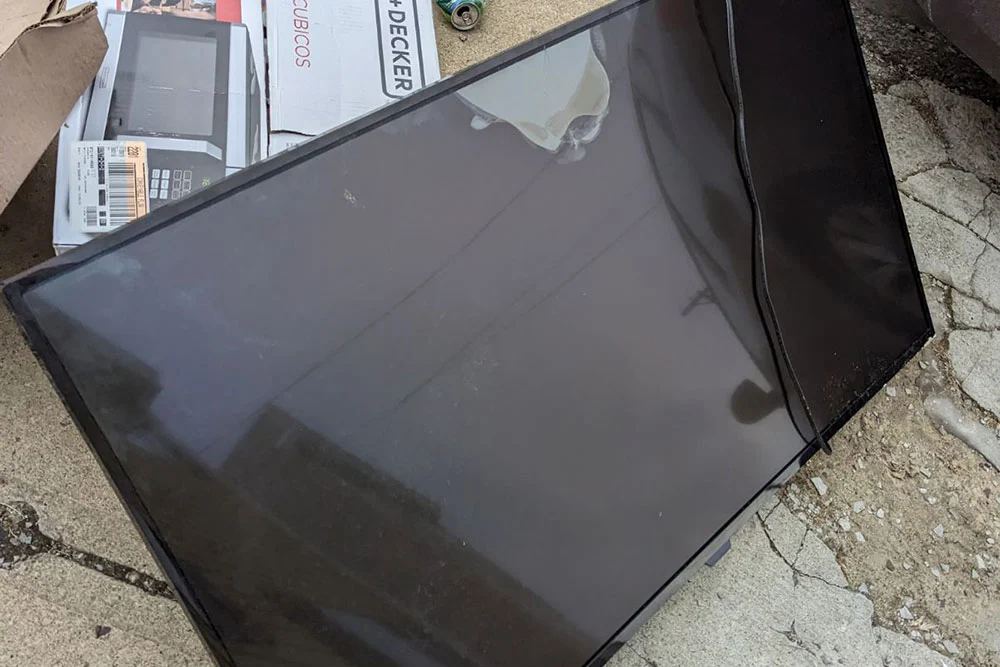 Black flatscreen TV on a San Diego driveway for TV recycling pickup