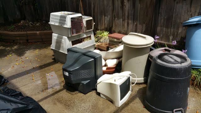 CRT television and monitor staged in a backyard for e-waste pickup