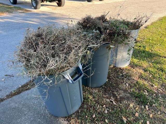 Three cans of trimmings staged at the curb for small-job yard waste pickup